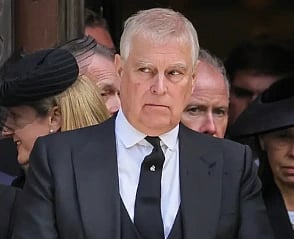 Image of former prince Andrew Mountbatten wearing a black suit, standing among crowd. 