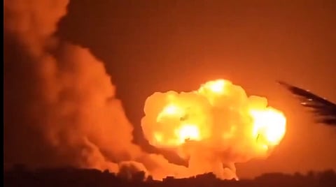 A massive explosion with bright orange flames and billowing smoke fills the night sky, creating a dramatic and intense scene.