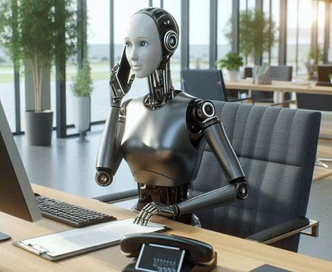 A humanoid robot sits at an office desk, holding a phone to its ear. Sunlight streams through large windows, highlighting a modern, professional workspace.
