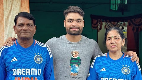 Rinku Singh (centre) with his parents on either side in Indian cricket shirts.