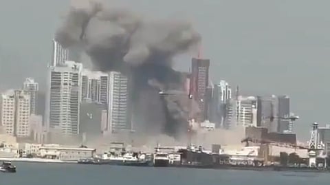 In the image black smoke is shown coming out of a metropolitan city Abu Dhabi