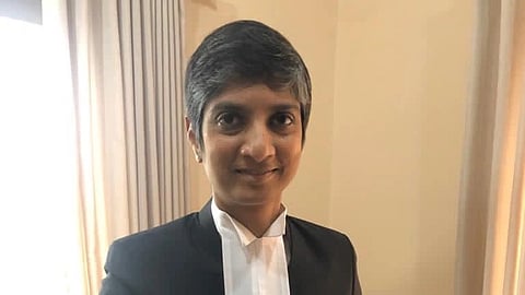 In the image Menaka Guruswamy is shown wearing lawyer clothes