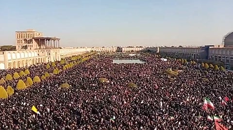 In the image many people are shown with Iran flags collected in Tehran road to mourn for the supreme leader