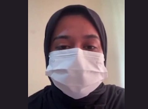 Image of a muslim women with her face covered in a white mask. 