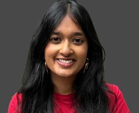 Image of Savitha Shan, an indian American student who was killed in Austin Mass Shooting. In the picture the background is grey and Shan is wearing a pinkish t shirt with her hair left loose. 
