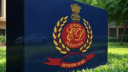 Sign of the Enforcement Directorate against a lush green backdrop. It features a red emblem with gold accents and Indian national insignia.
