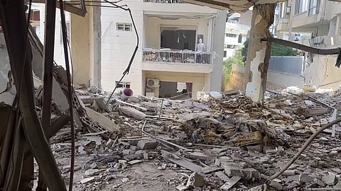 Rubble of a building with another damaged building across the road