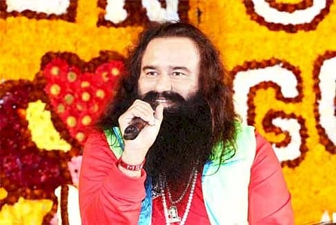 Gurmeet Ram Rahim holding a mic and addressign a congregation