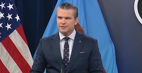 In the image Pentagon secretary pete is shown adressing people in a formal attire behind him is USA flag