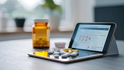 Pills lying on a tablet with another standing in front of it and a medicine bottle in the back