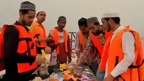 Men in life jackets surround a table filled with food