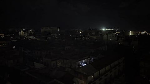 A dark skyline with a few lights in the distance