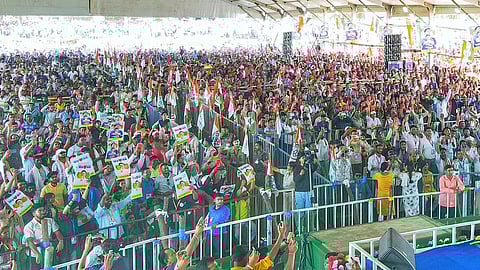 A crowd of TMC supporters raise flags and posters at a rally ahead of the 2026 Assembly Election