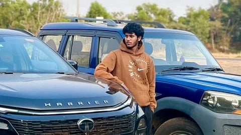 Soham Sushant Naik posing between two cars