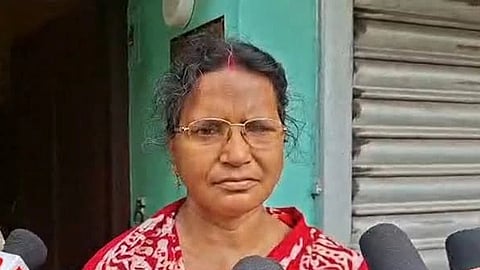Ratna Debnath standing in front of media mics