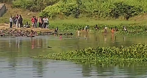 people stand beside a river