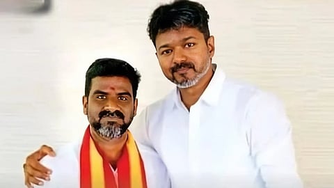 In the image Actor Vijay is shown with R. Prakasam posing in front of the camera