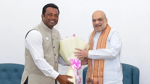 Leander Paes posing next to Amit Shah with a bouquet