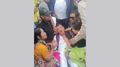 Screengrab of the video Assam Congress uploaded on X, showing Naduar candidate Sunil Kumar Chhetri hurt, lying on the ground and attended by his supporters