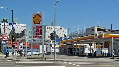A gas station in Los Angeles with a board showing prices and the Shell logo in front