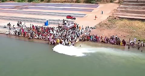 On the banks of the narmada river, devotees gather as milk is poured into the river