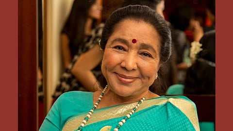In the image Lata Mangeshkar is shown smiling at the camera