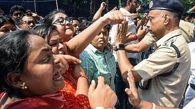 Protesters passionately confront a police officer in uniform. Emotions are high, with pointing fingers and stern expressions amidst the tense crowd.