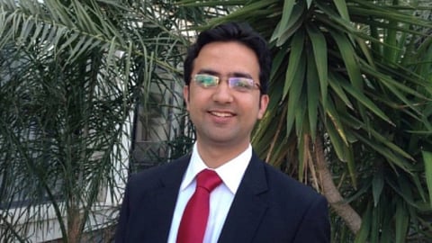 Mahmood Shah Habibi, wearing suit and tie, smiling