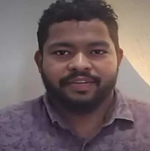 Image of one of the owners of Mehr Mandi grills. He is seen standing in front of wall and speaking in front of the camera.