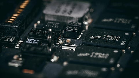 Close-up of a circuit board with various electronic components, including microchips and resistors. The image conveys a technical, detailed focus.