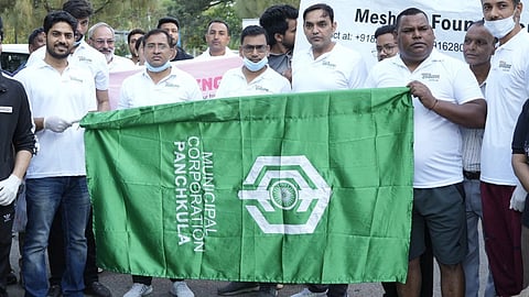 people holding up a green banner reading 'Panchkula Municipal Corporation'