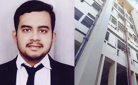 A professional-looking man in a suit poses confidently beside a multi-story building. The scene conveys a sense of ambition and professionalism.