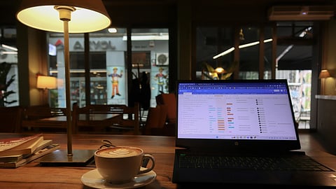 In the image a cafe is shown with a laptop