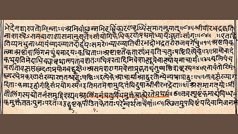Ancient manuscript in Sanskrit with black and red letters on aged paper, featuring dense script lines. The text conveys a historical or religious significance.