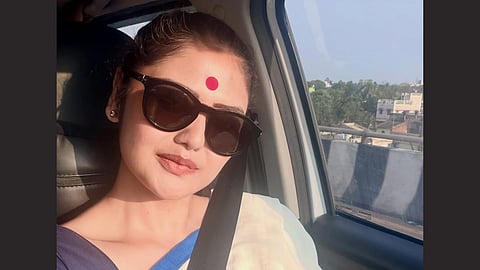 Sayani Ghosh is shown in her car traveling she is posing for the camera