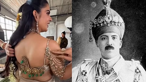 A woman in a decorated sari and jewels smiles in a rustic room, turning sideways. Next to her is a vintage photo of a finely dressed man in regal attire.