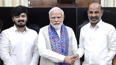 Bandi Bhageerath (left), Narendra Modi (centre), Bandi Sanjay Kumar (right)