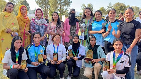 female student athletes sitting in front of a row of teachers