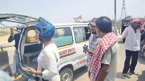 people stand in front of an ambulance ona bridge