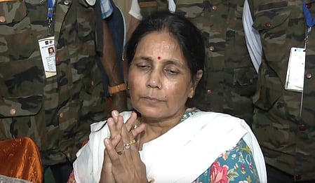 Twisha Sharma's mother is joining her hands and talking about the incident in front of the police officers.