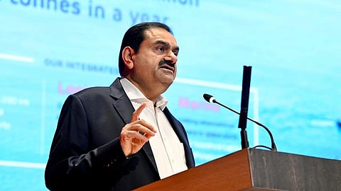 In the image Gautam Adani is shown addressing people