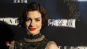 Hollywood actress Anne Hathaway is posing in front of the camera and she is wearing a black sequence dress. 