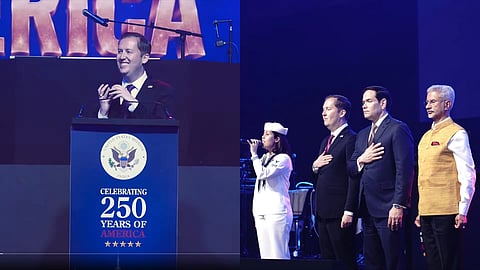 US Ambassador Sergio Gor holding a phone to the microphone as Donald Trump addresses guests at a US Embassy event in New Delhi.