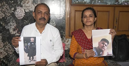 In the image two people are shown showing seperate pictures of Ahmedabad medical student who are missing in Georgia