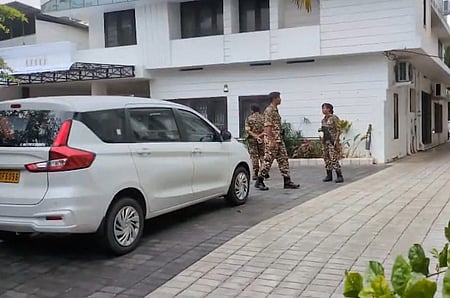 Officers standing outside a white house three officers are shown in the CISF uniform there is a car outside the house