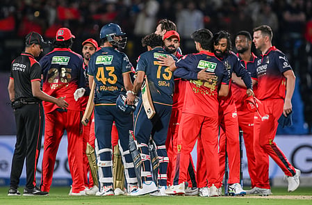 In the image RCB team is shown hugging other team members in the IPL match cricket Stadium