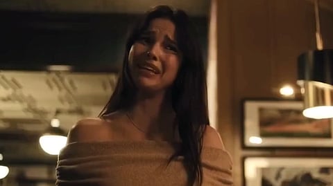 A screenshot from a seen in obsession movie where a women is seen standing and crying