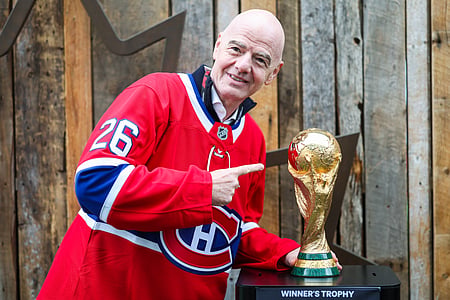 In the image FIFA President Gianni Infantino  is shown pointing towards the FIFA Cup
