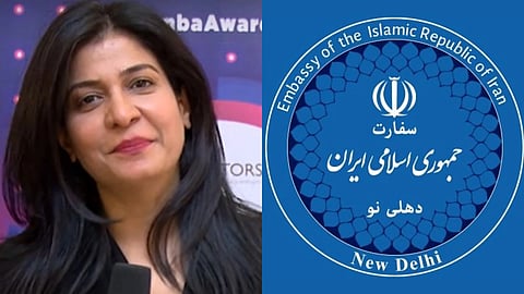 Anjana Om Kashyap, Aap Tak Anchor, smiling softly holds a microphone against a backdrop with text. Next to her, a blue emblem of the Iranian Embassy in New Delhi.