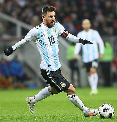 Image of Lionel Messi playing for Argentina. he is in in an Argentina jersey, number 10, kicks a ball on a grassy field. The scene is dynamic, conveying focus and intensity.
